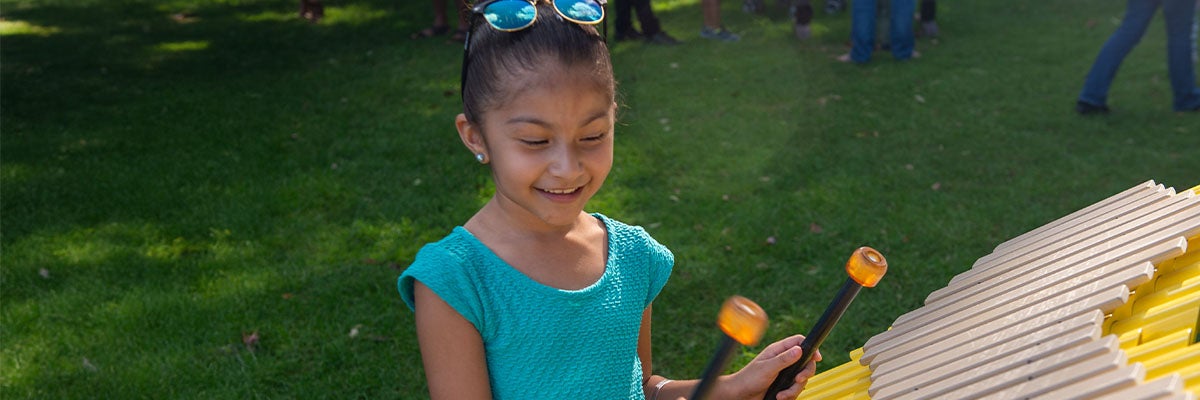 Girl playing mallet instrument at Ravinia's KidsLawn